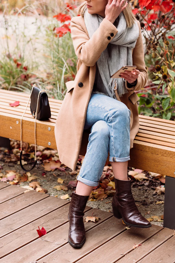 Woman in a fall outfit sitting on a park bench