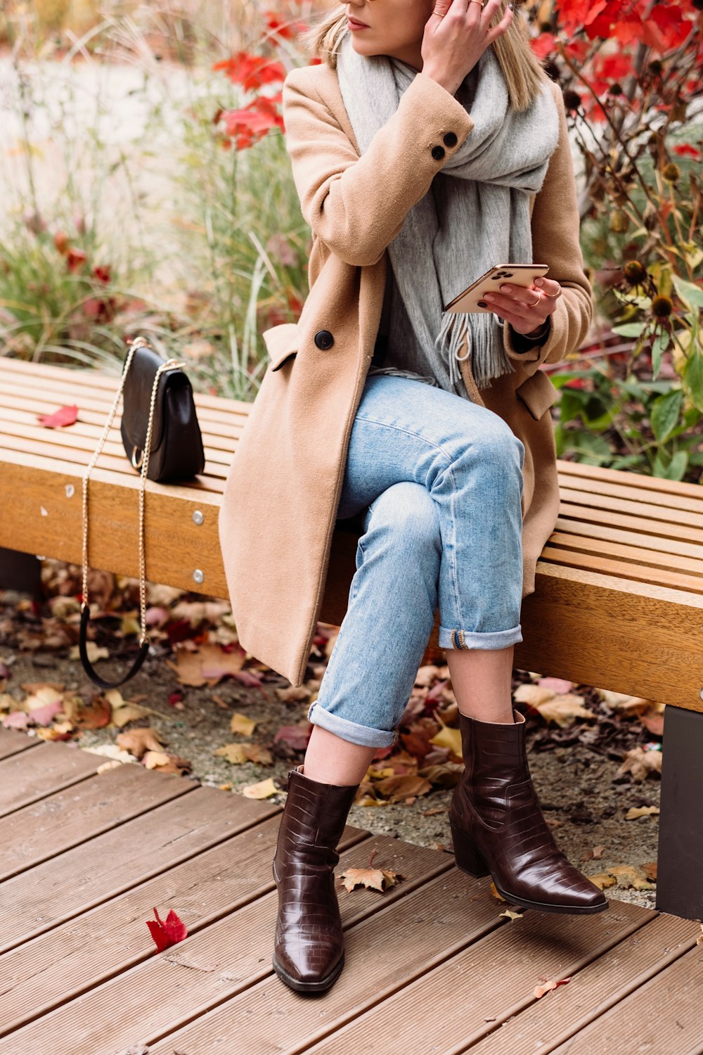 a woman sitting on a wooden bench in a park