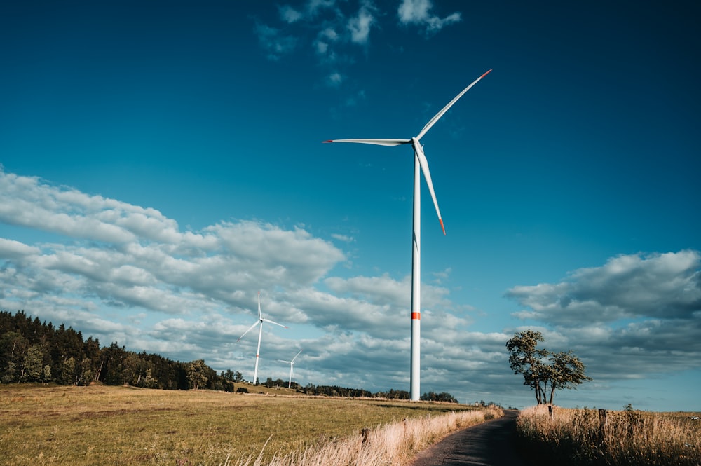 a wind turbine on a dirt road in the middle of a field