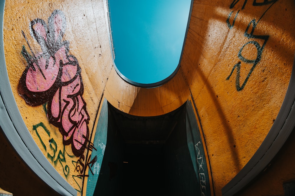 a skateboarder is going down a ramp with graffiti on it