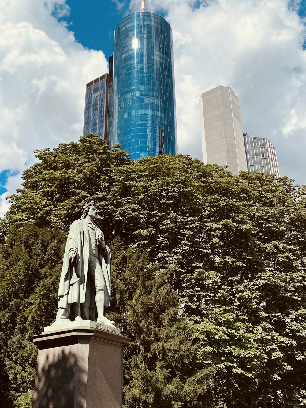 a statue of a man in front of a tall building