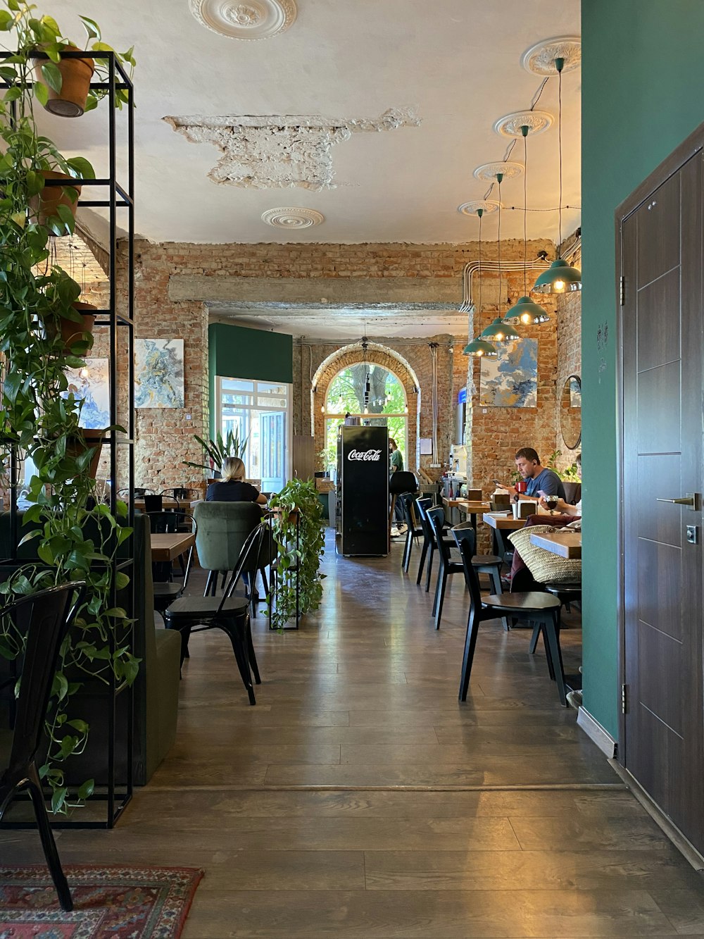 a restaurant with tables, chairs, and potted plants