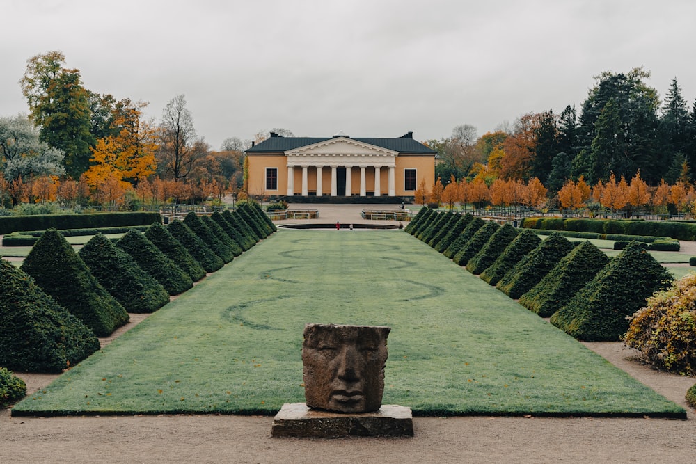 a sculpture in the middle of a formal garden