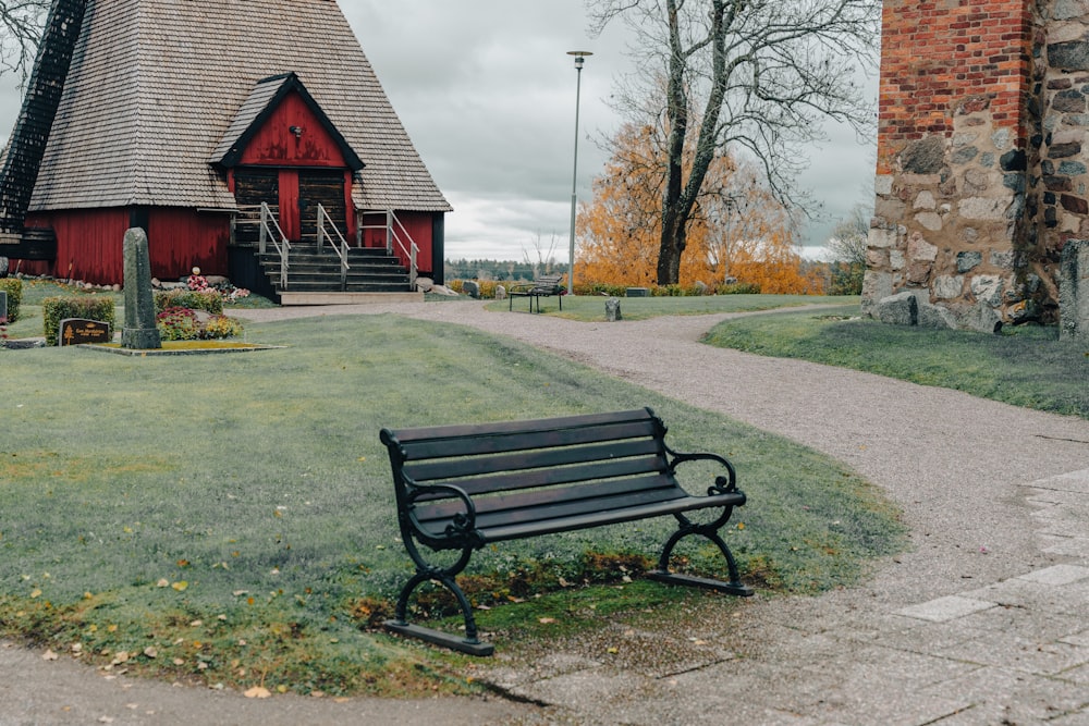 a bench sitting in front of a red barn
