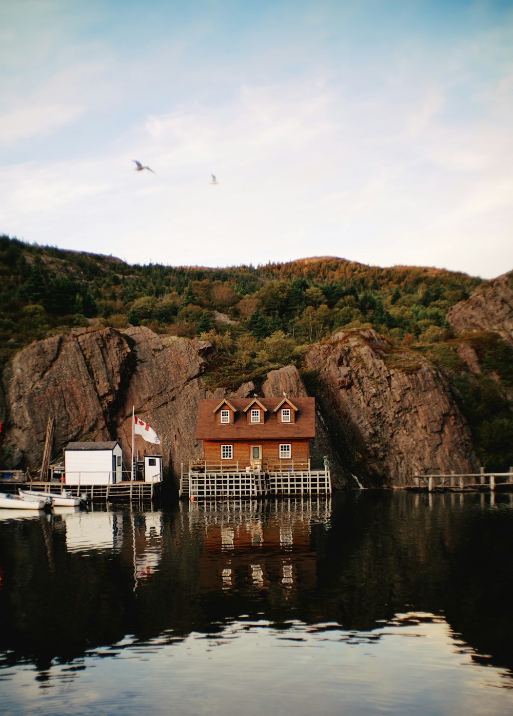 a house sitting on the edge of a body of water