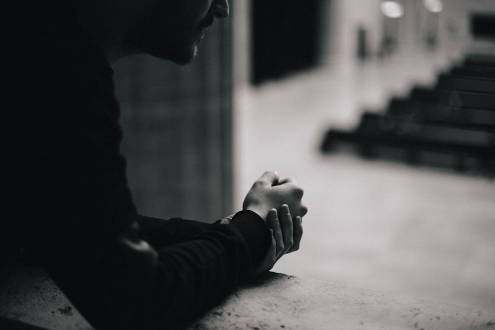 a black and white photo of a person sitting at a table