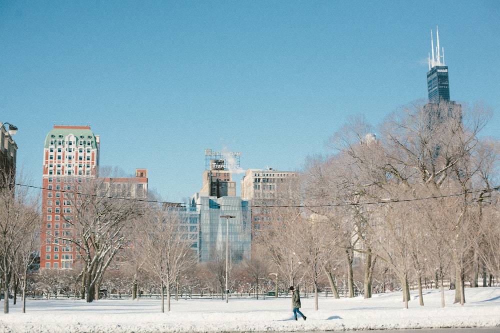 a person walking in the snow in a city park