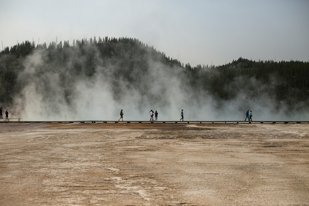 a group of people standing in front of a geyser