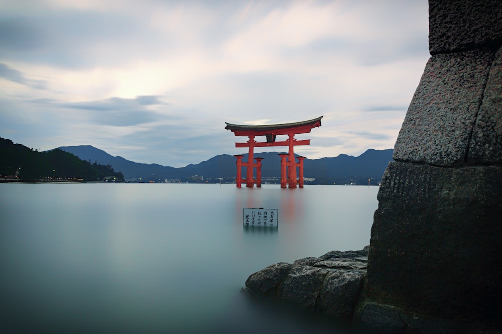 a large red gate sitting on top of a body of water