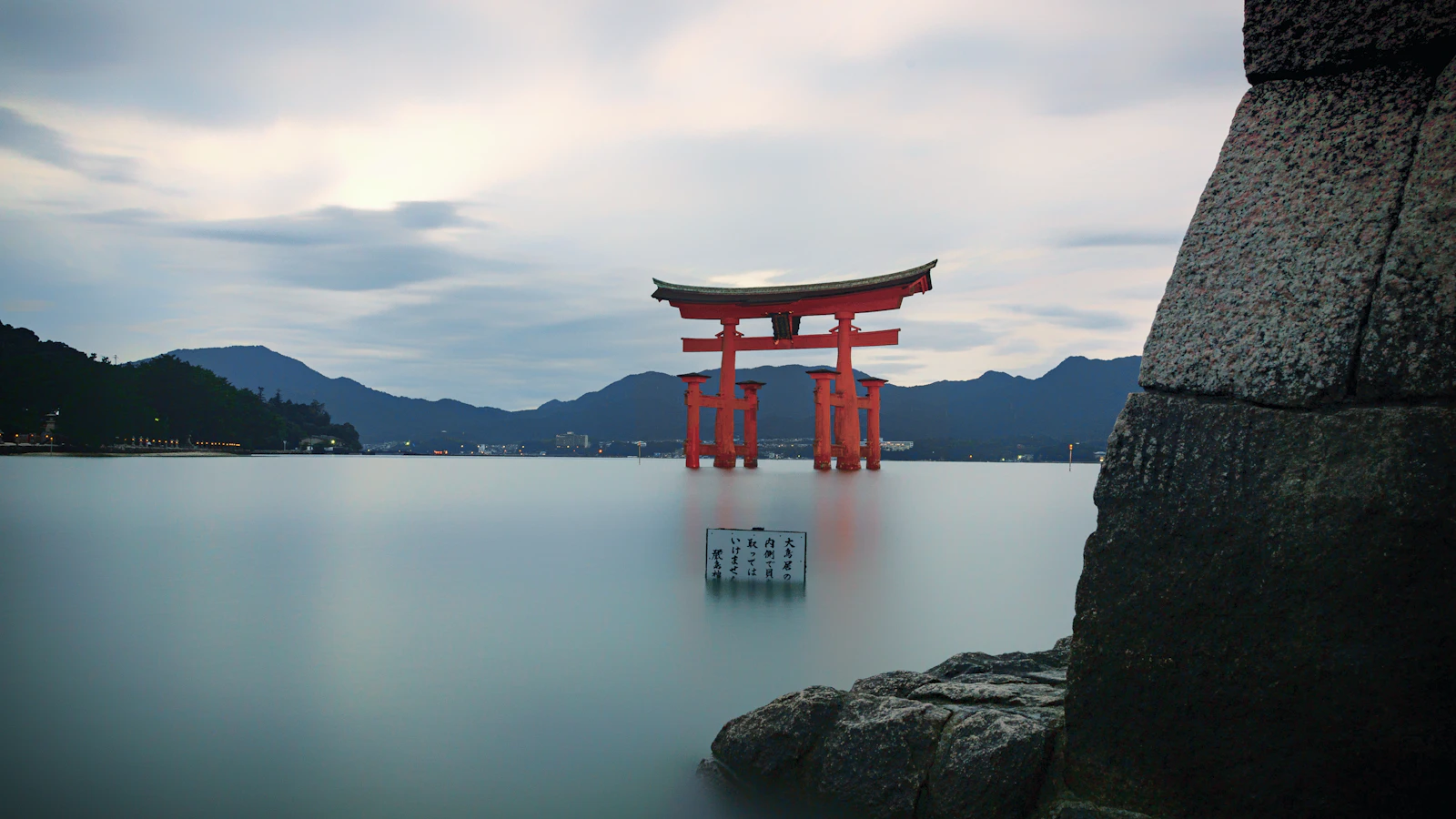 a large red gate sitting on top of a body of water