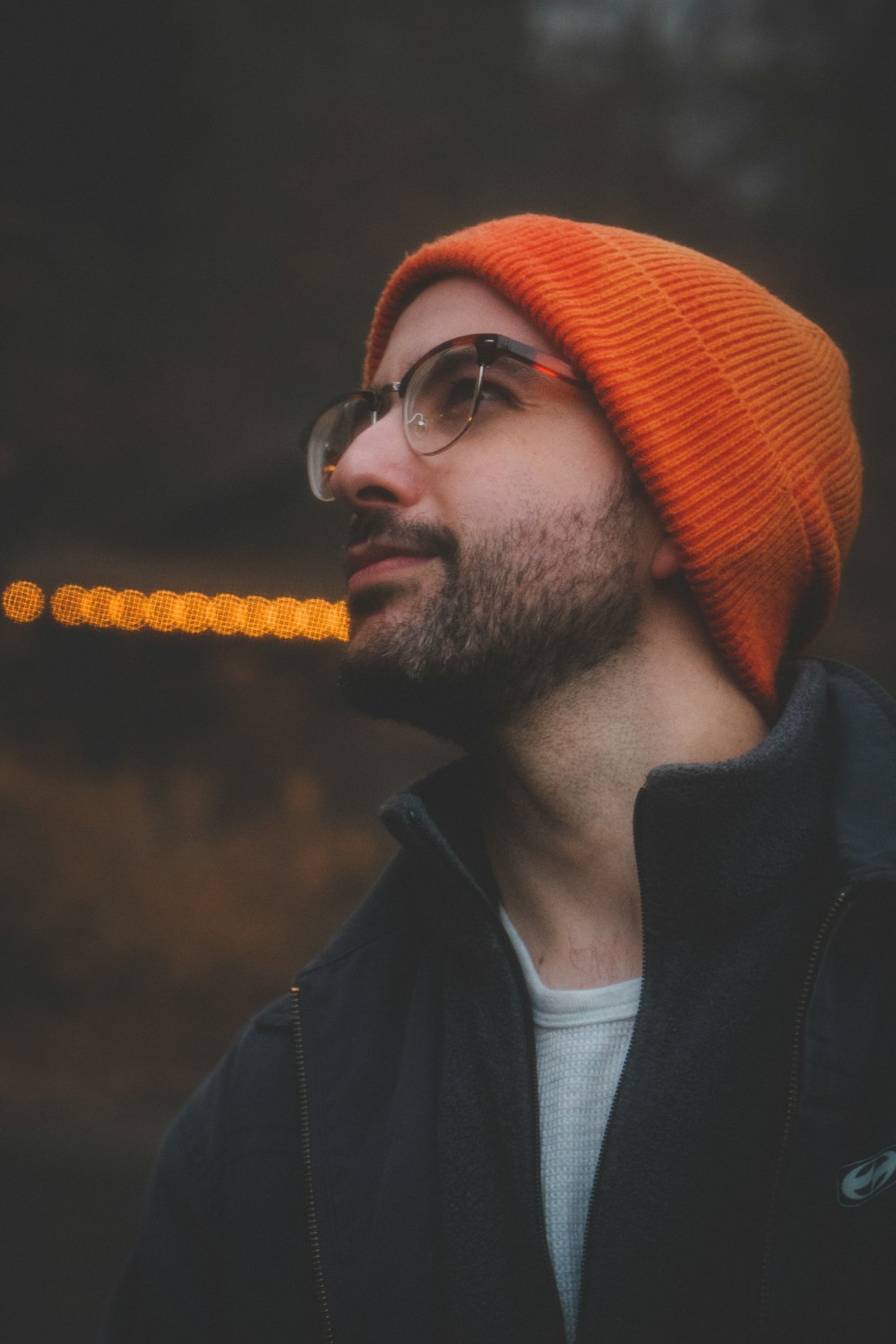 a man wearing a hat and glasses with a cigarette in his mouth