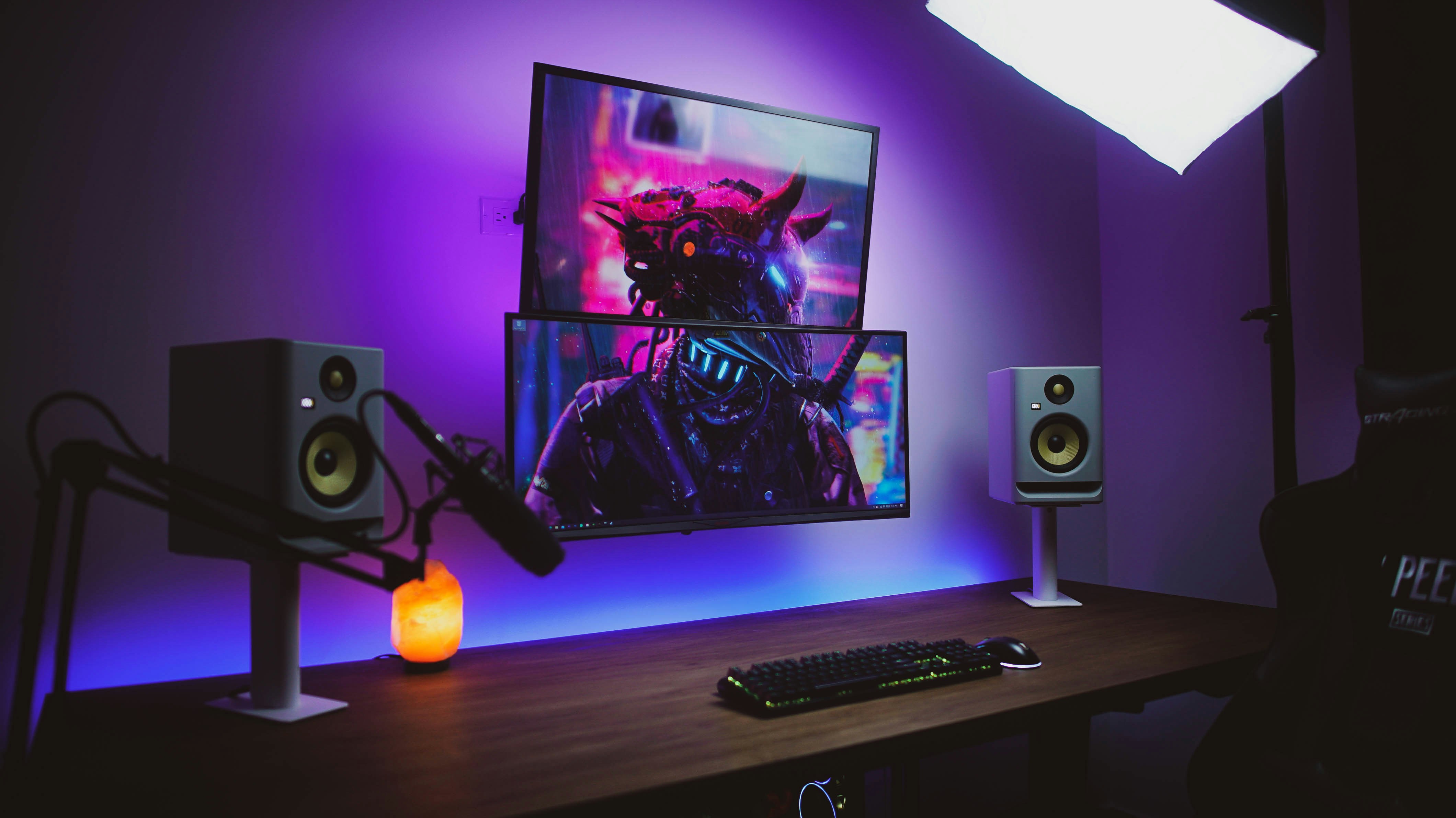 a desk with speakers and a picture on the wall