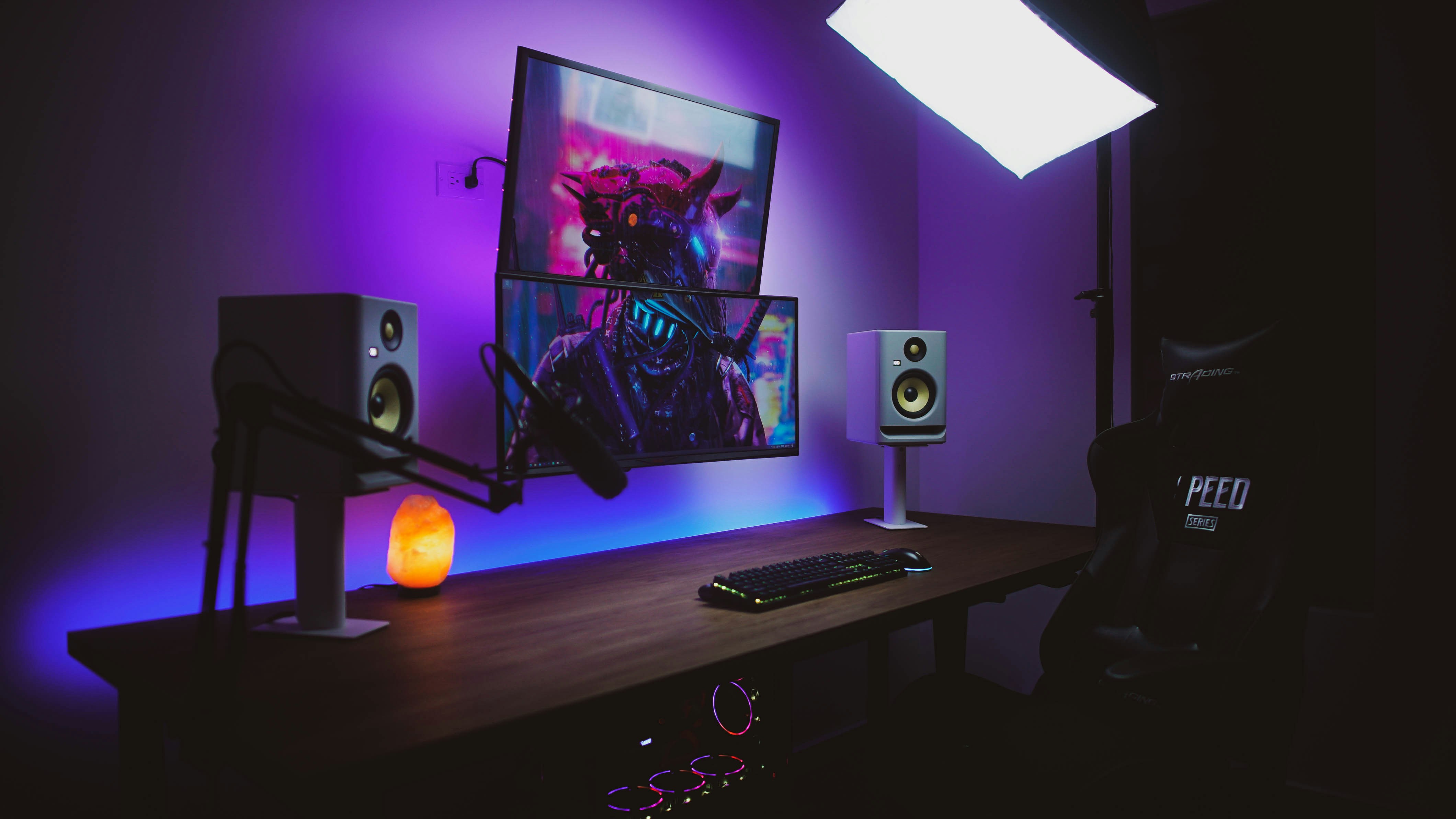 a desk with speakers and a painting on the wall