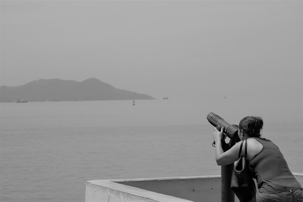 a woman taking a picture of a body of water