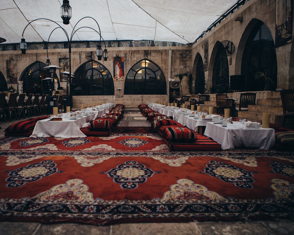 une salle de banquet avec tapis rouge et tables