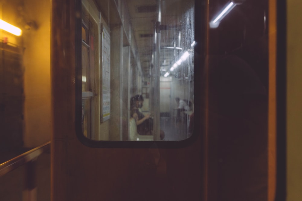 a train with a reflection of a person on the window