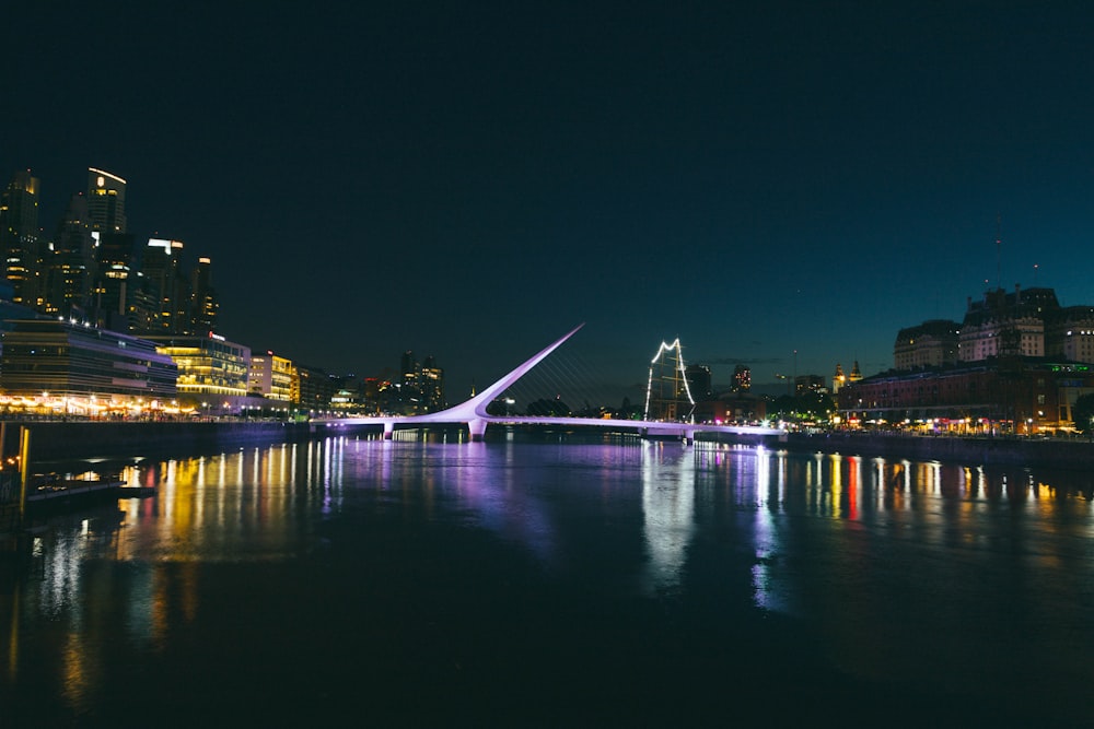 a bridge over a river with a city in the background