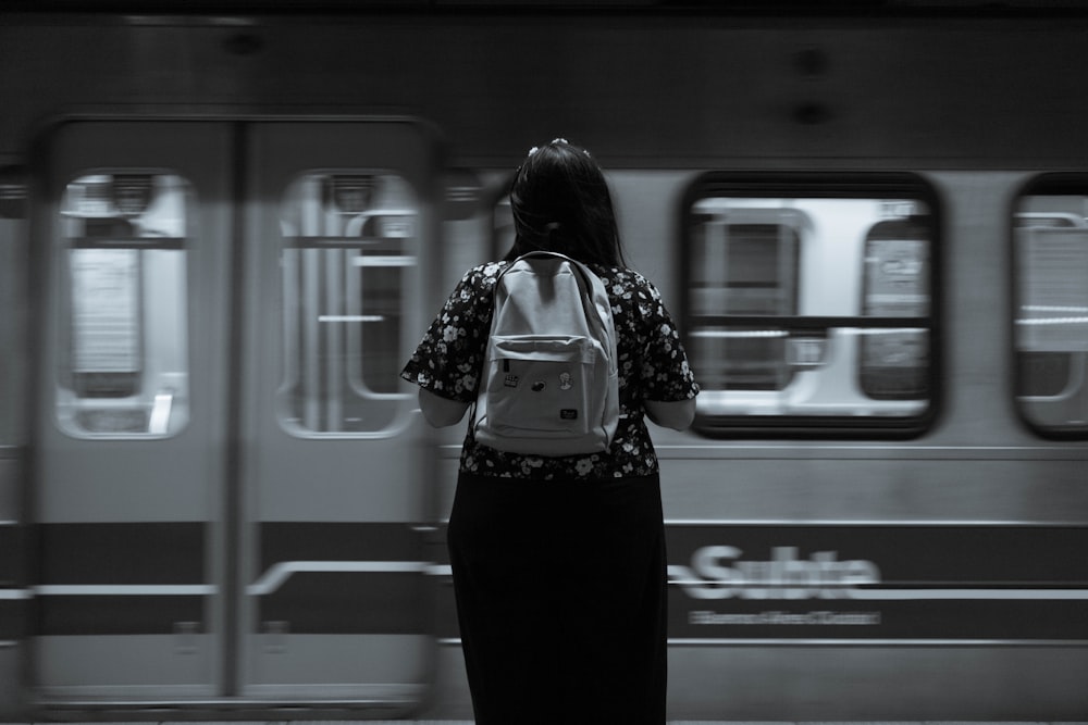 a woman standing in front of a subway train