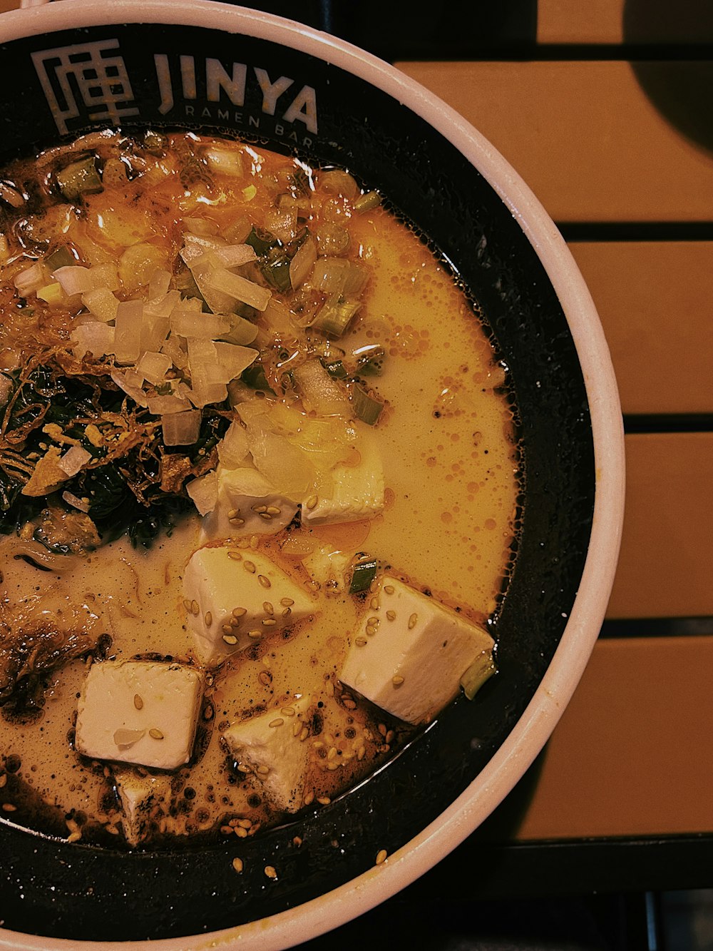 a bowl of soup with tofu and onions