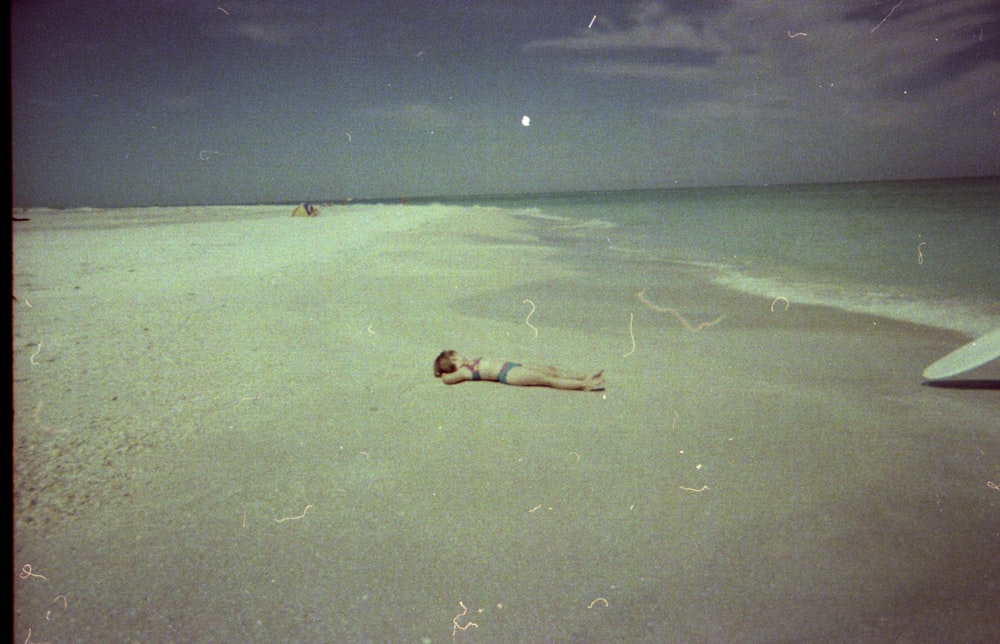 a person laying in the sand on a beach