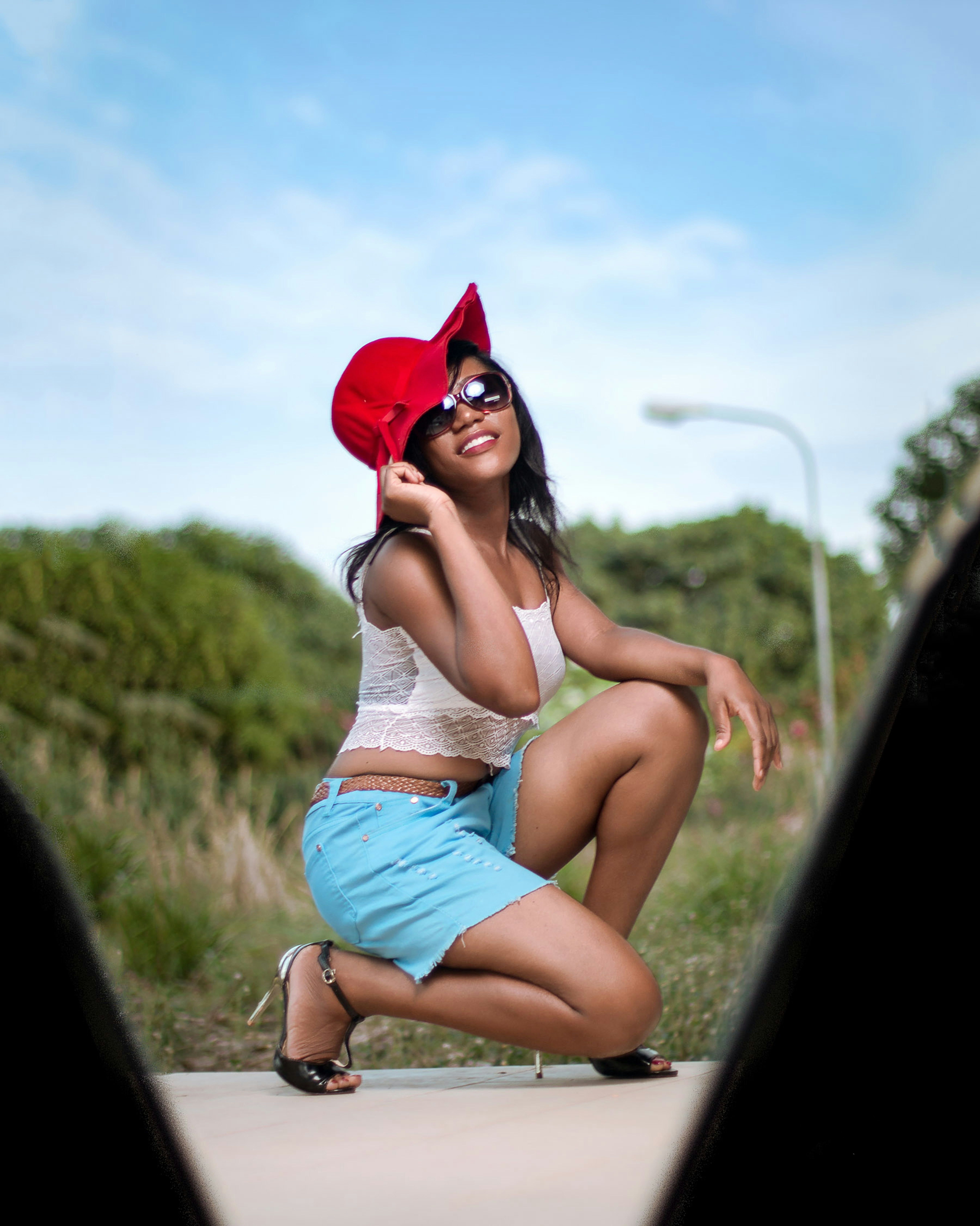 A woman sitting on the ground with a hat on her head photo – Free ...