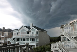 a storm rolls in over a row of houses