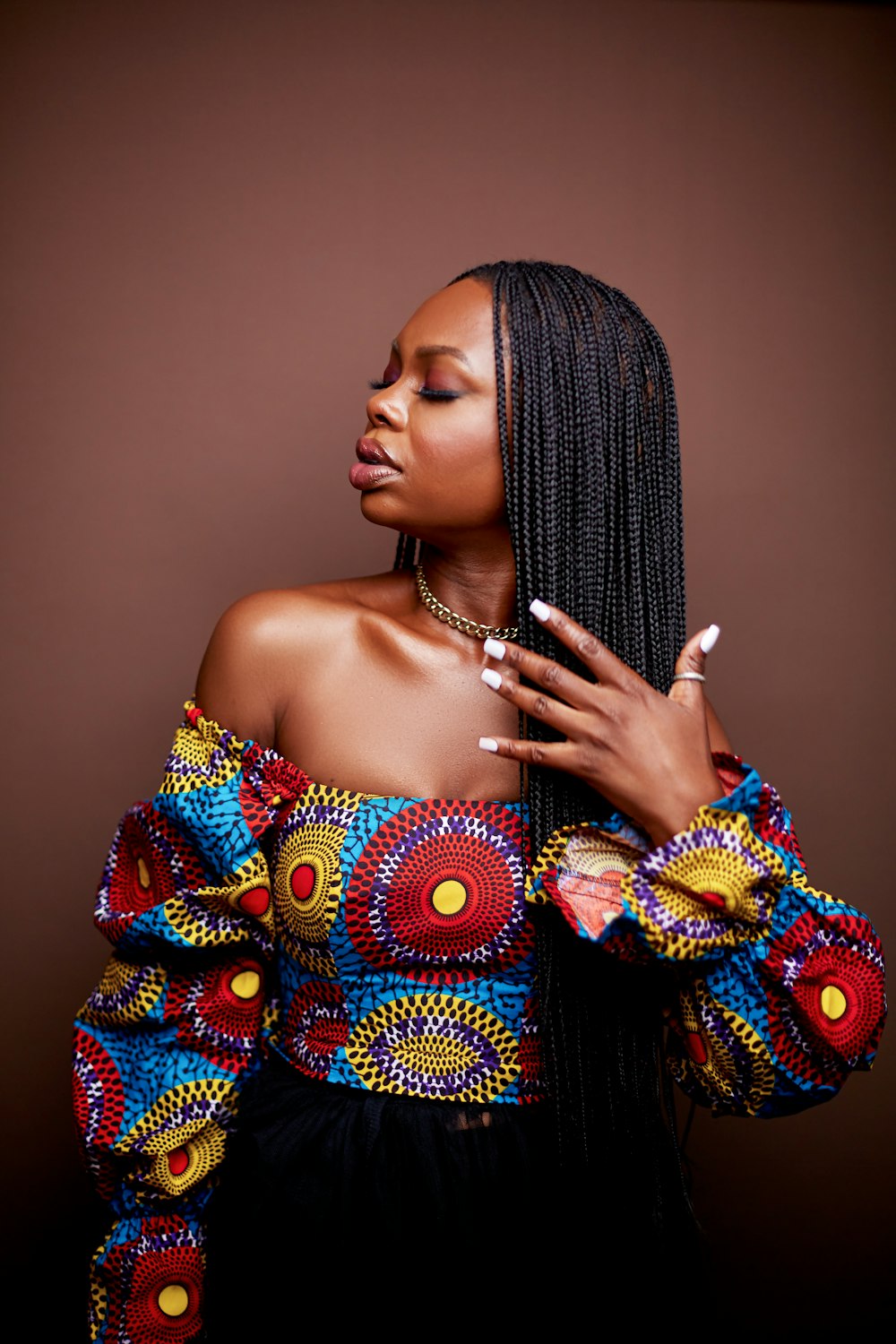 a woman in a colorful top with a cigarette in her hand