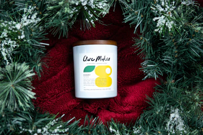 Modern personalized candle with a warm yellow-orange glow and a neat label