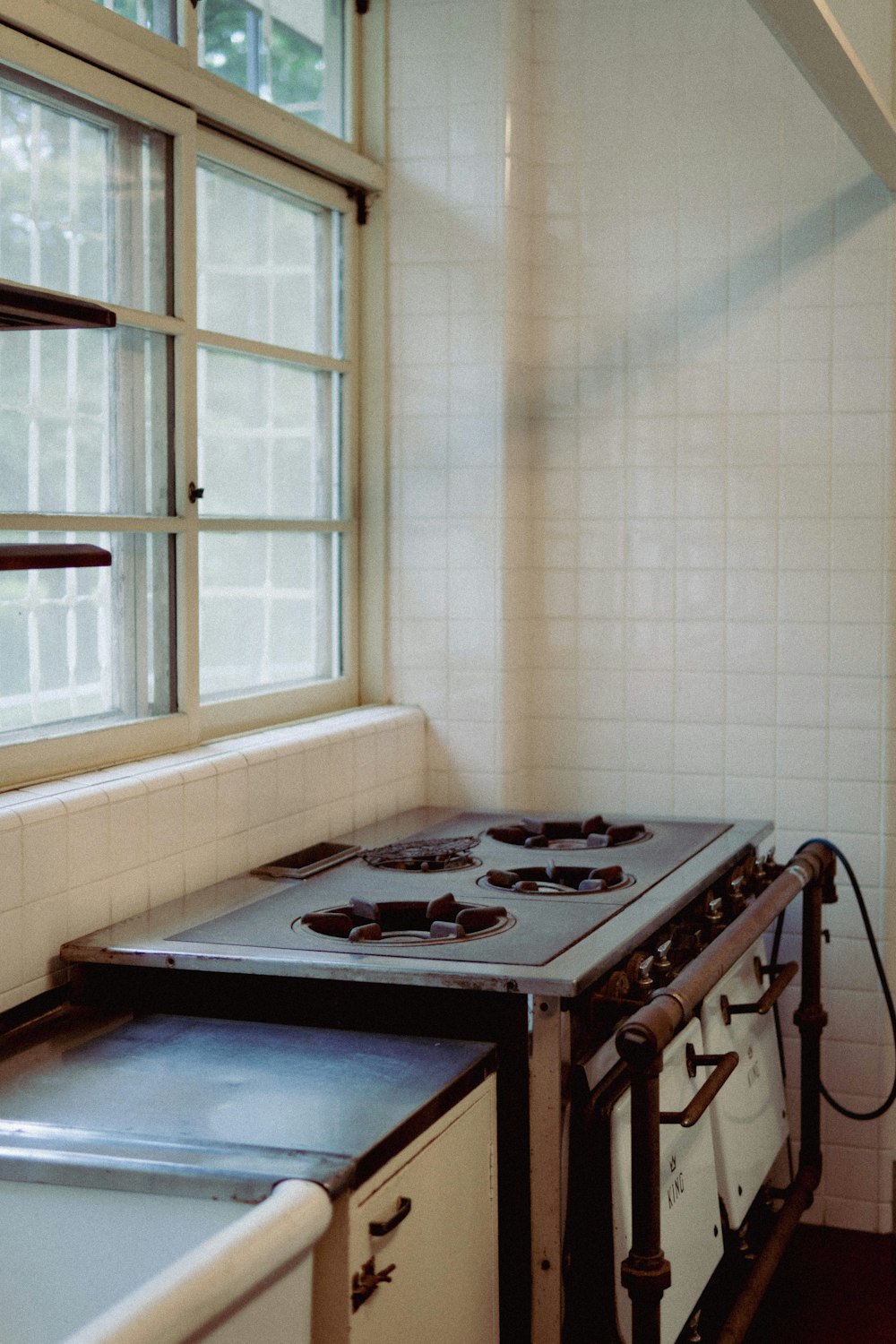 a stove top oven sitting in a kitchen next to a window
