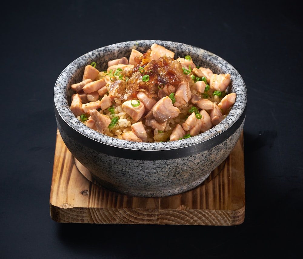 a bowl of food on a wooden board