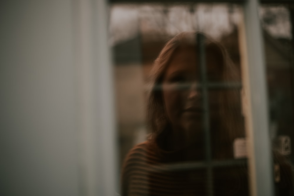 uma foto borrada de uma mulher olhando pela janela