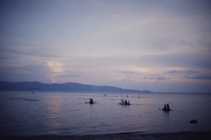 Guests enjoying a peaceful kayak ride across calm island waters at dawn.