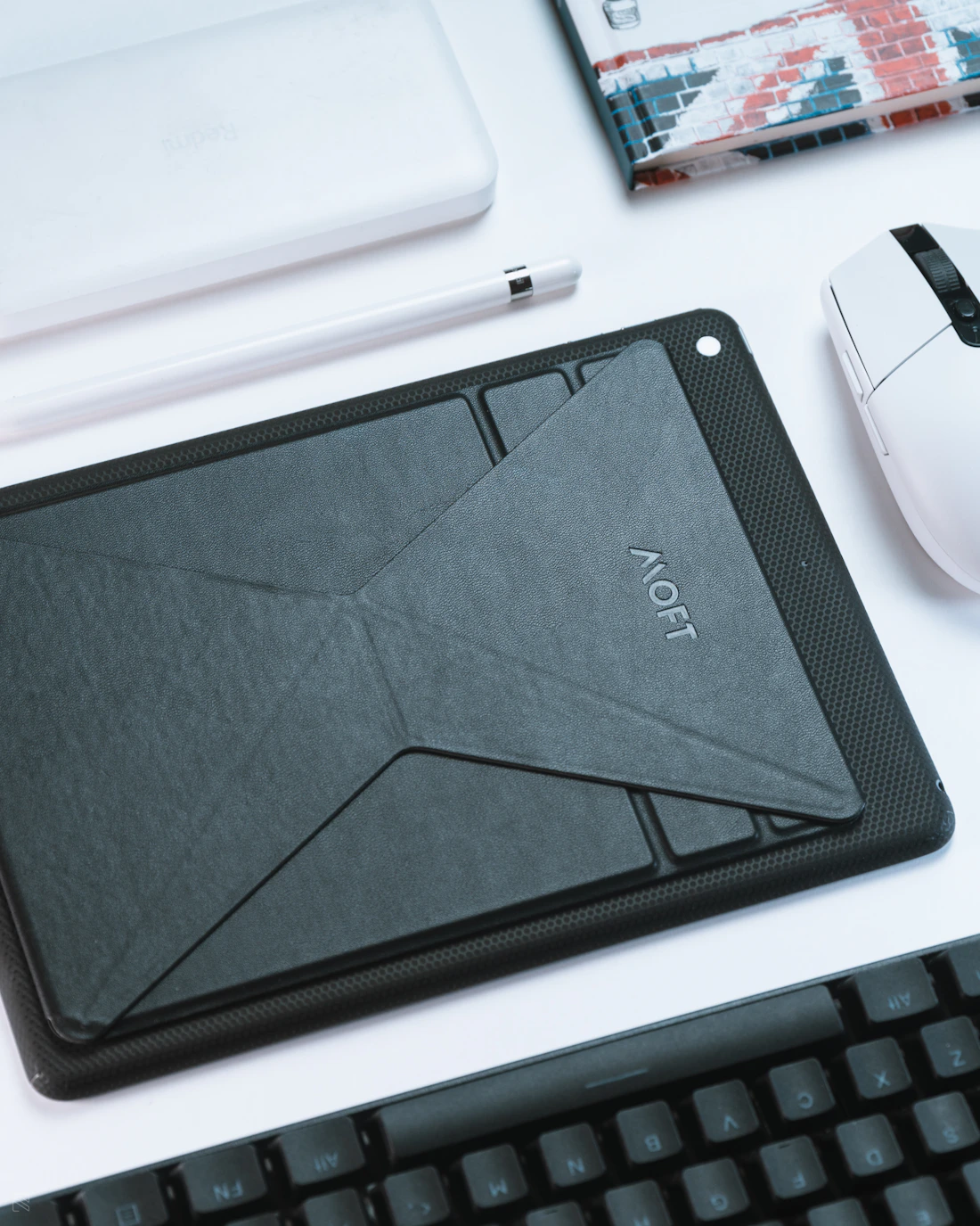Tablet positioned on a stand beside a keyboard in a workspace