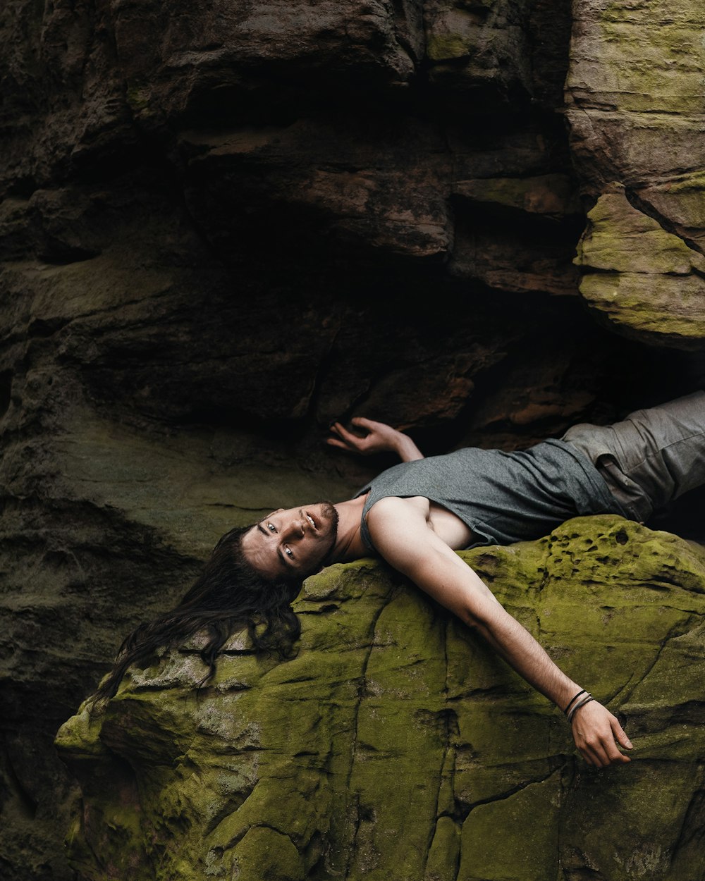 a woman laying on top of a large rock