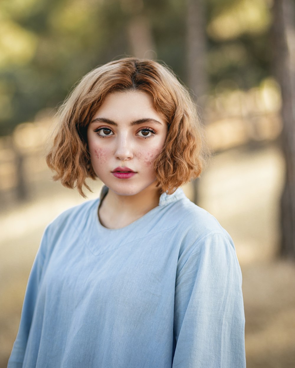 a woman with red hair and a blue shirt