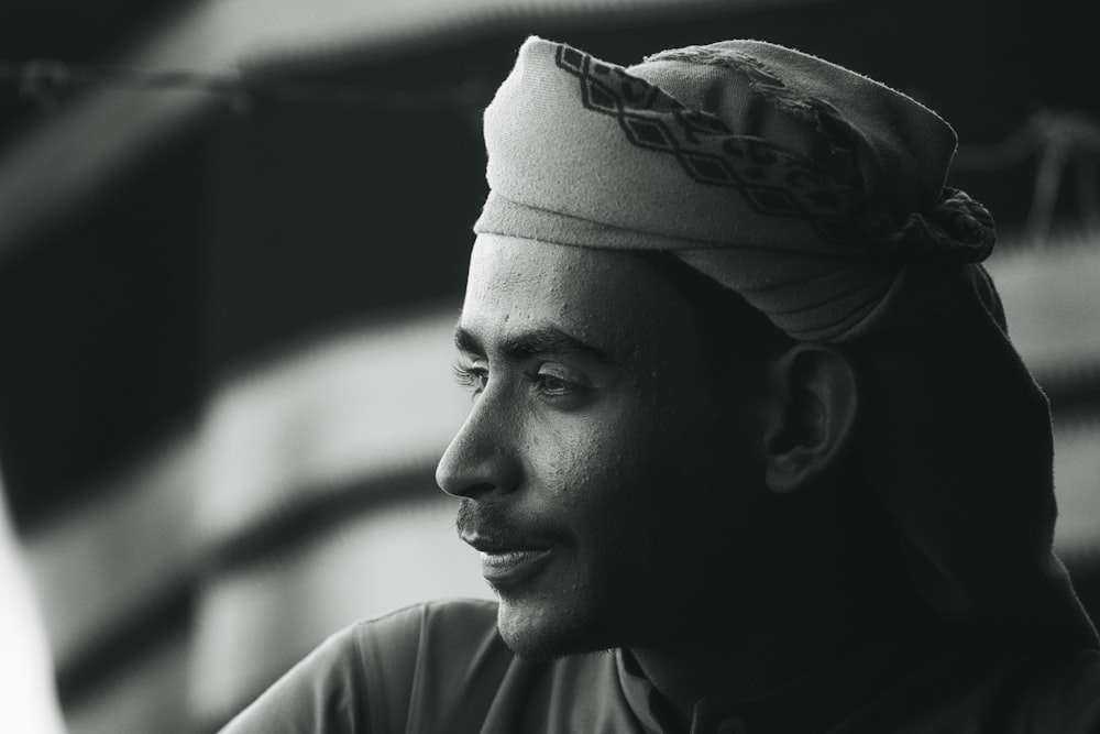 a man in a turban looks off into the distance