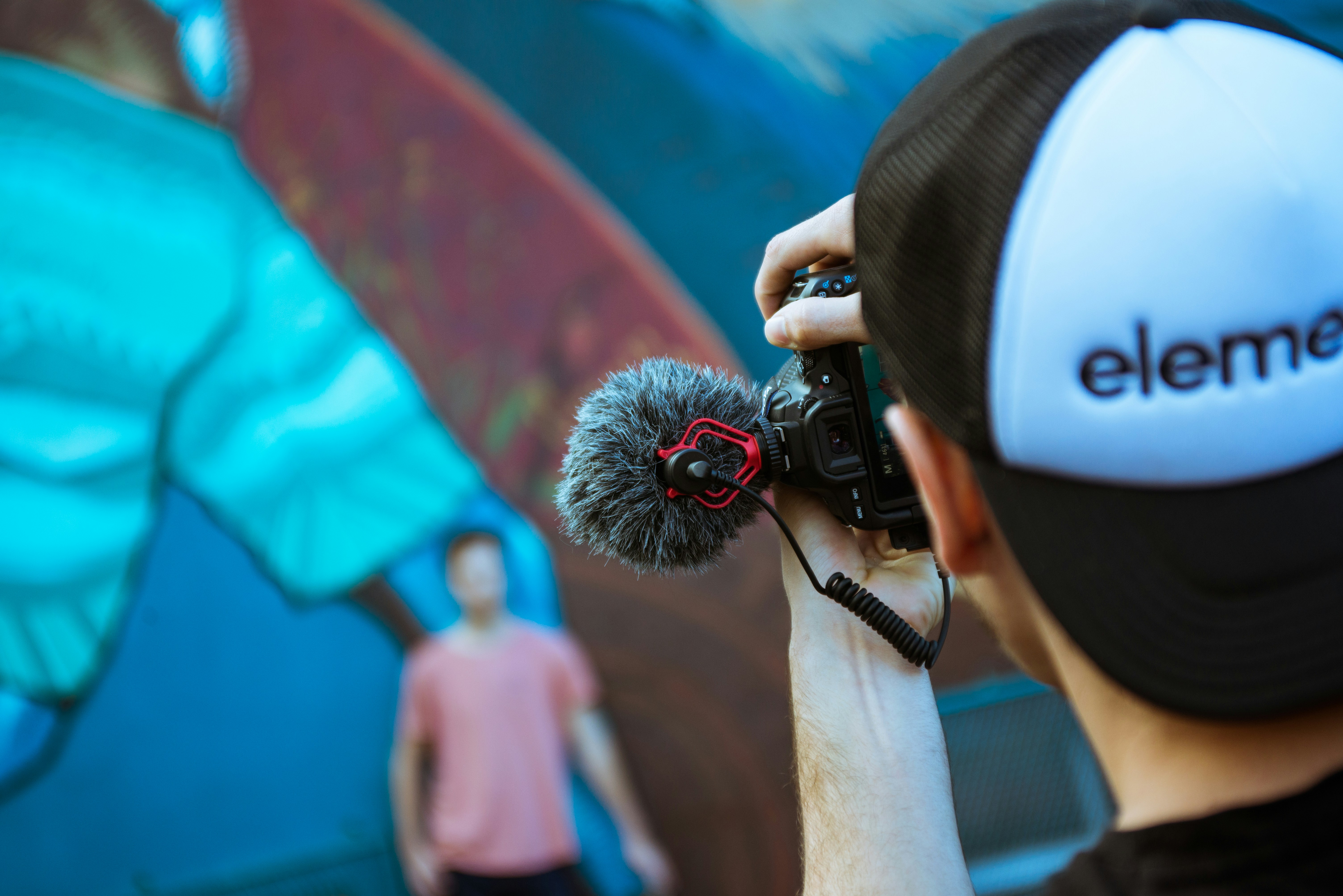 a man holding a microphone in front of a painting