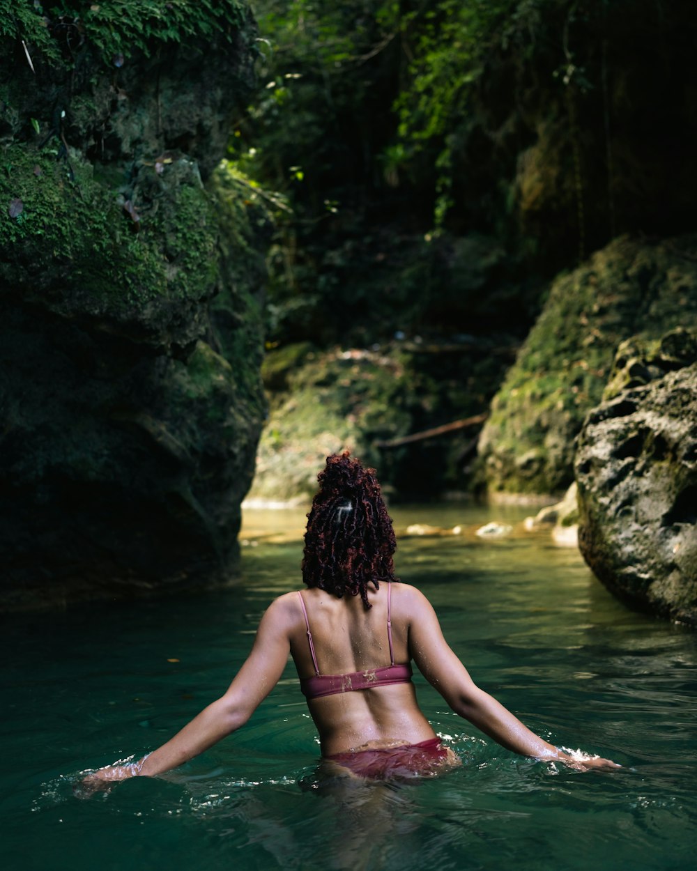 Una donna in bikini seduta in un fiume