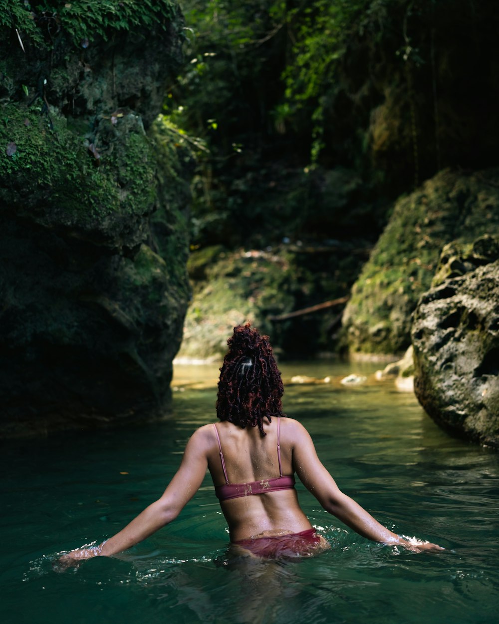 Eine Frau im Bikini sitzt in einem Fluss