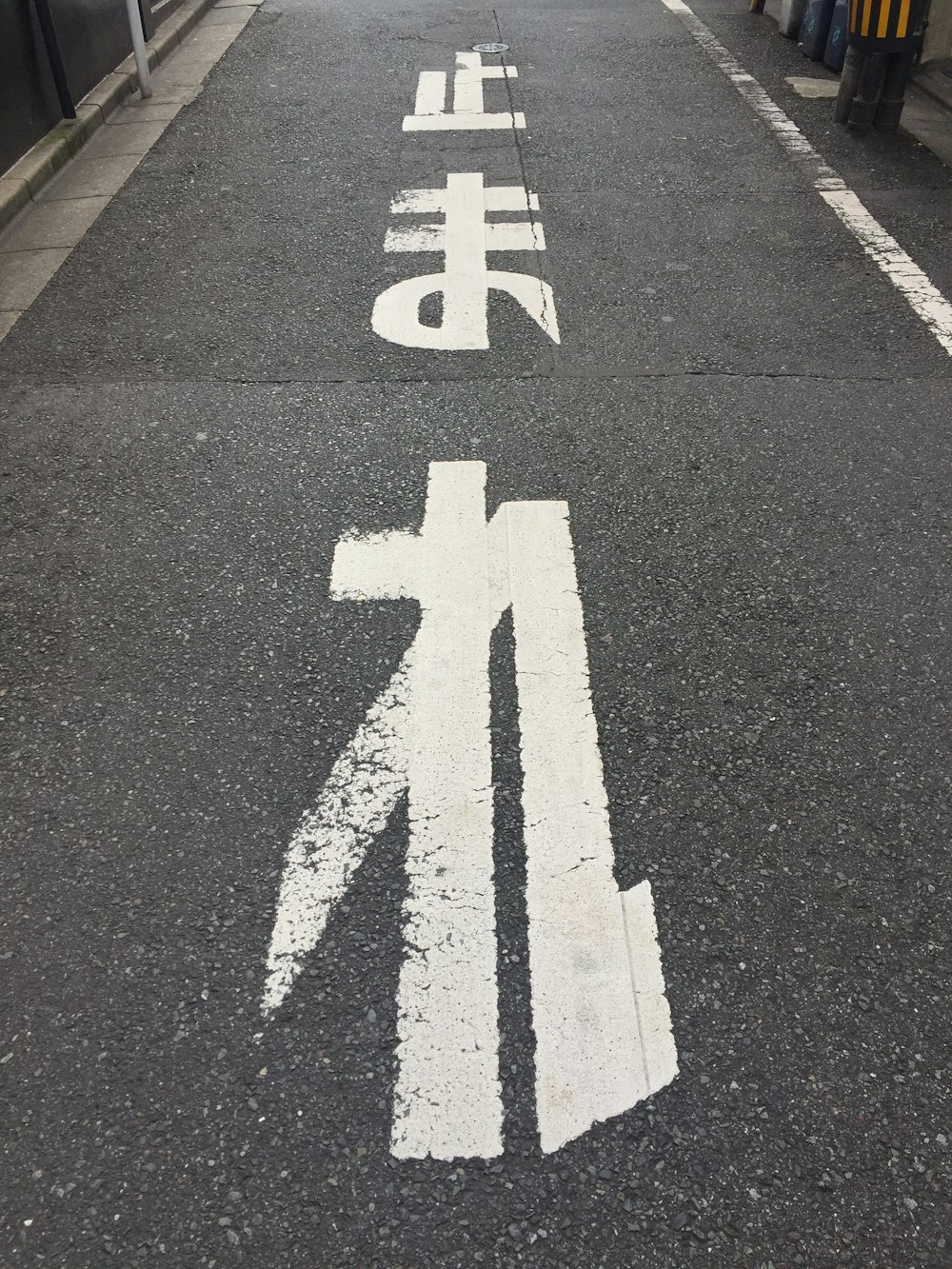 a street with a cross painted on the side of it