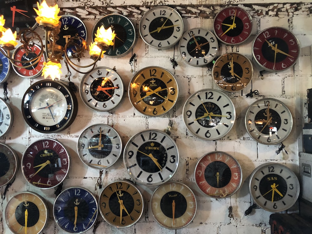 a bunch of clocks that are on a wall