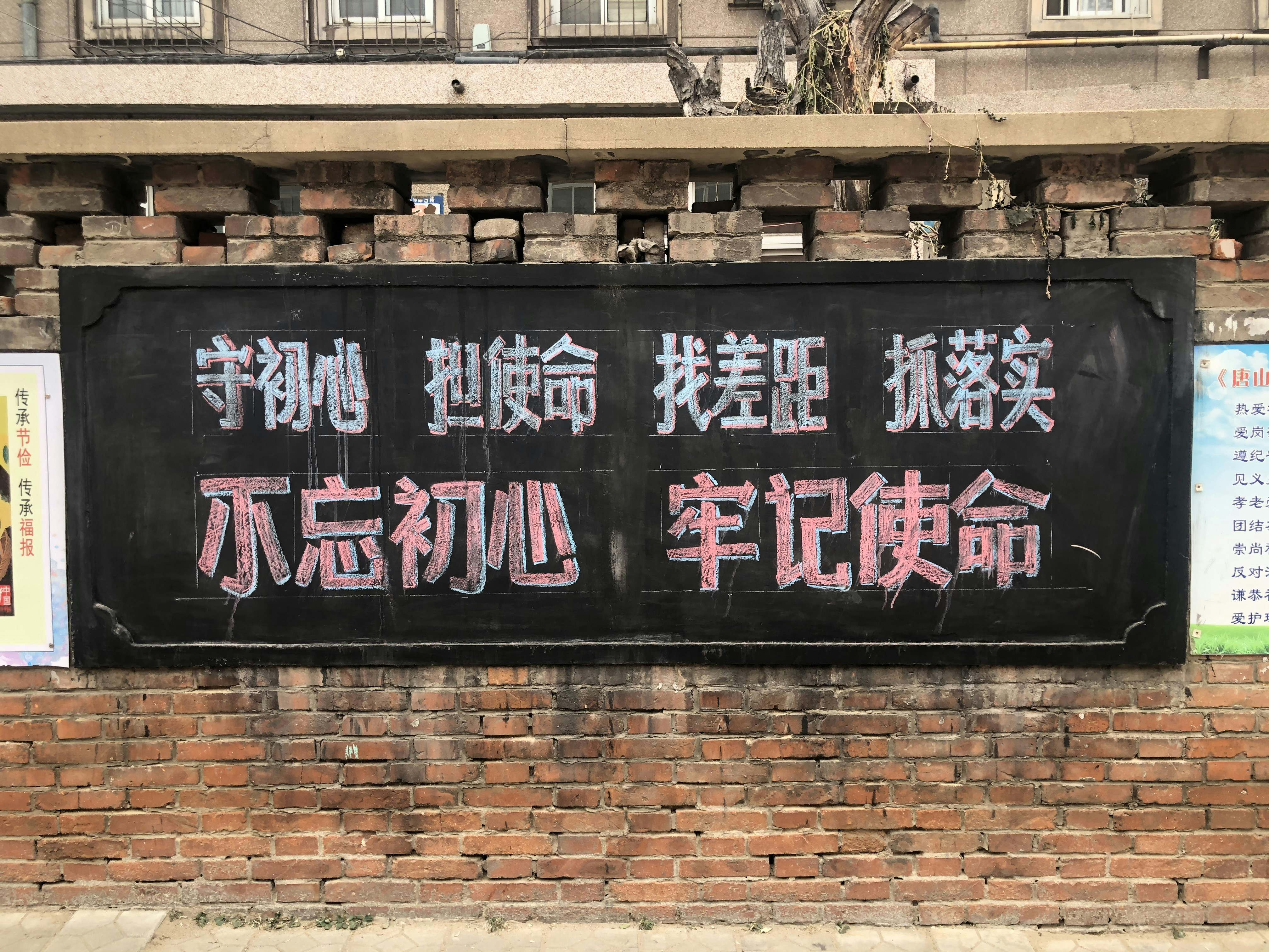 a sign on a brick wall in an asian language