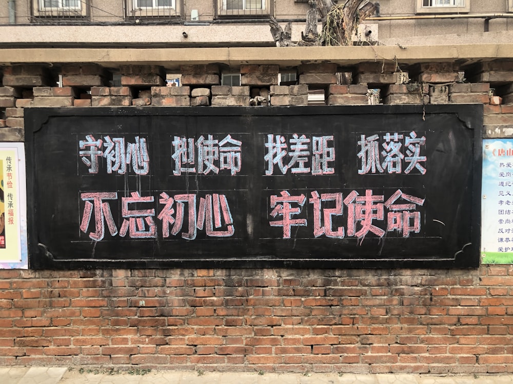 a sign on a brick wall in an asian language