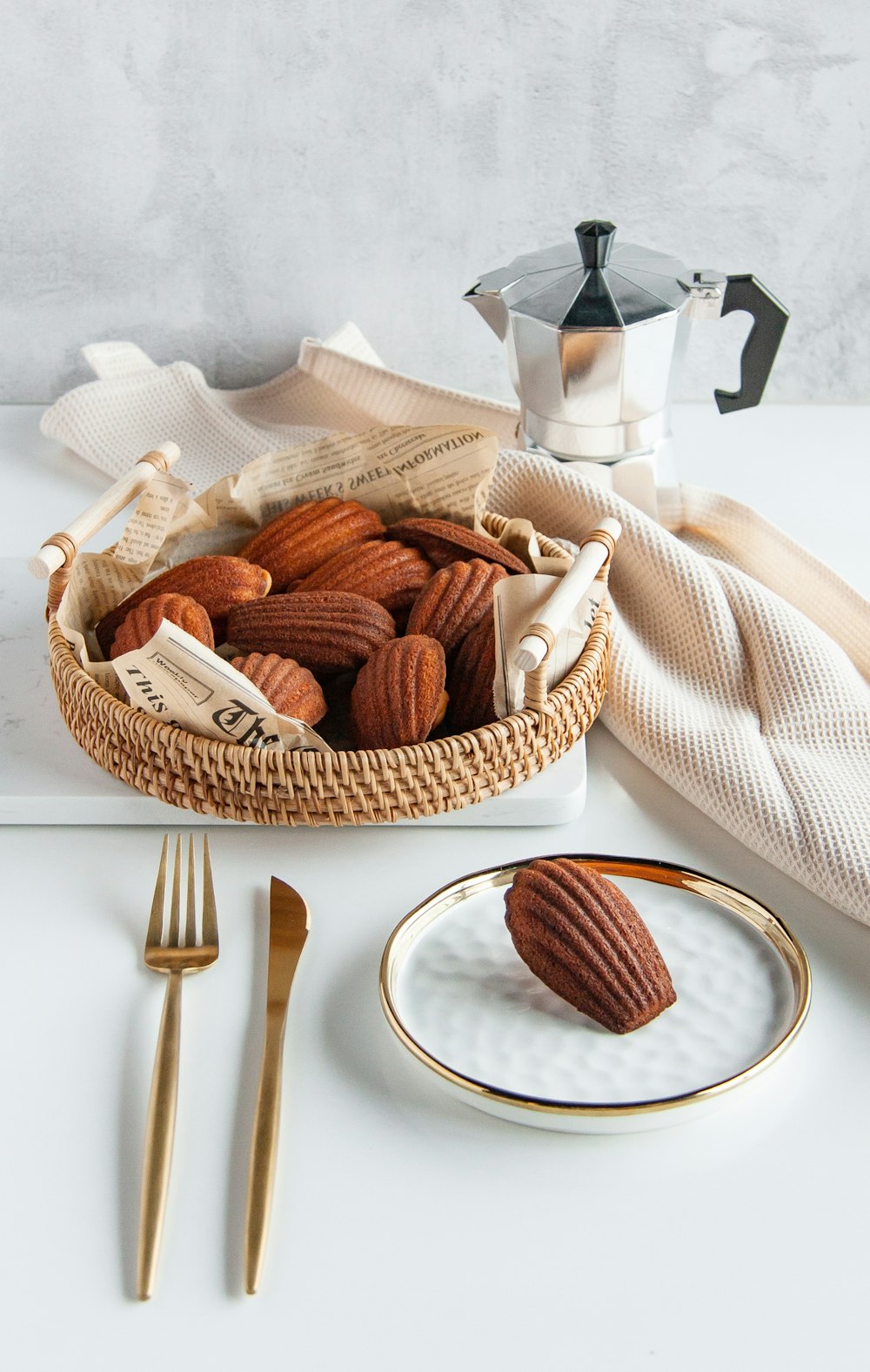 a basket of nuts on a plate next to a cup of coffee