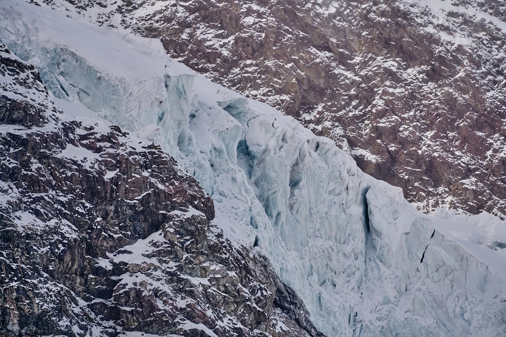 a very tall ice cliff with a mountain in the background