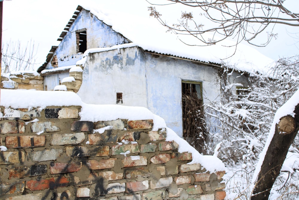 a brick wall and a building covered in snow