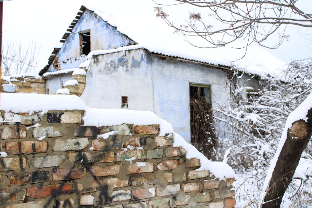 eine Ziegelmauer und ein mit Schnee bedecktes Gebäude