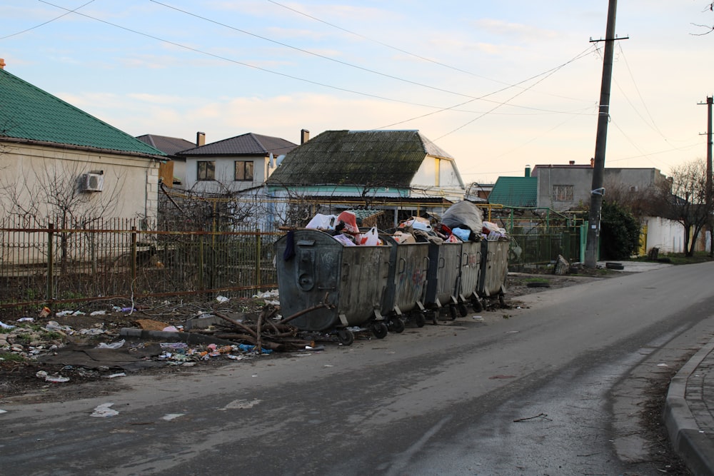 a group of people sitting in a dumpster on the side of a road