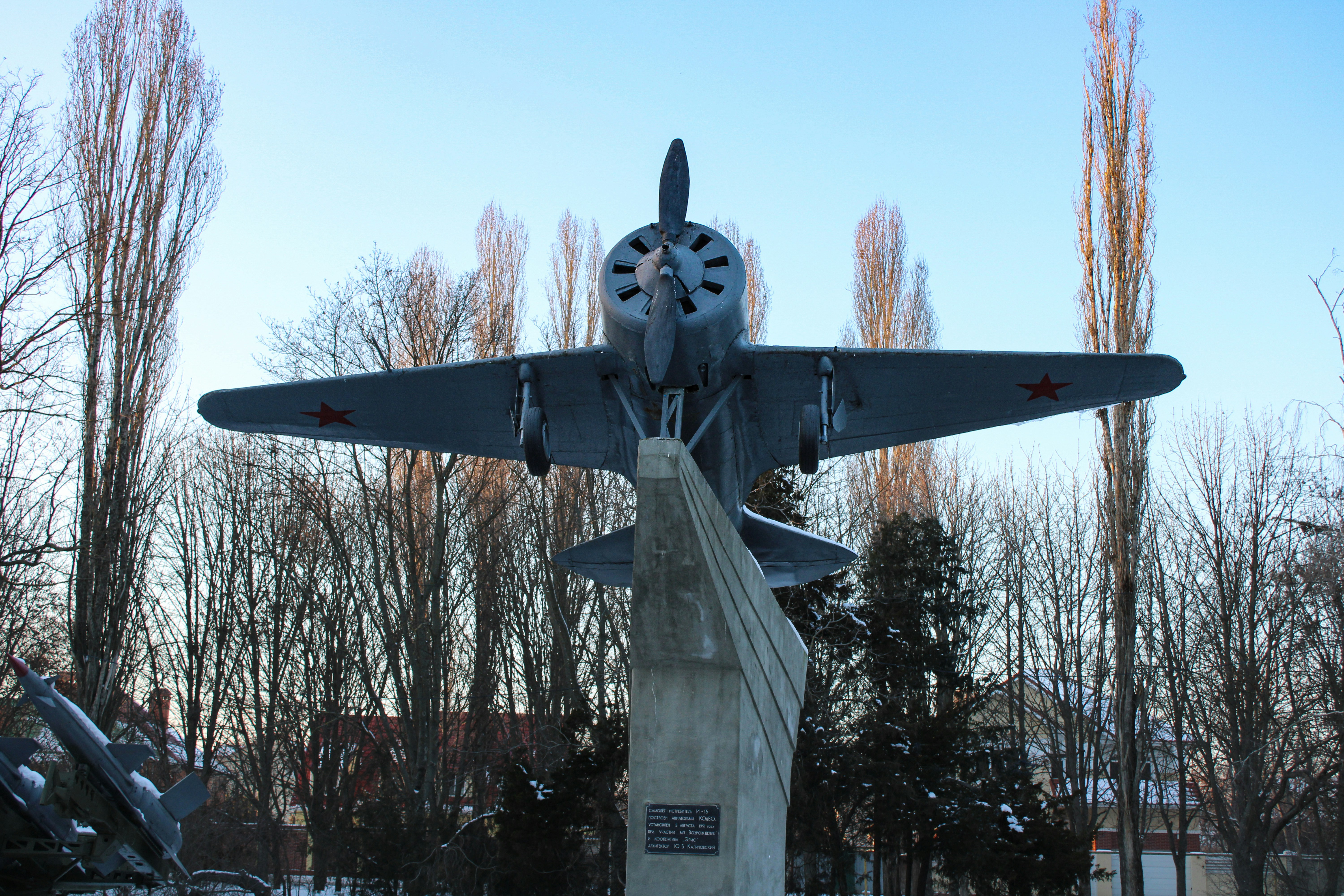a statue of a fighter plane in a park, Military airplane in the park