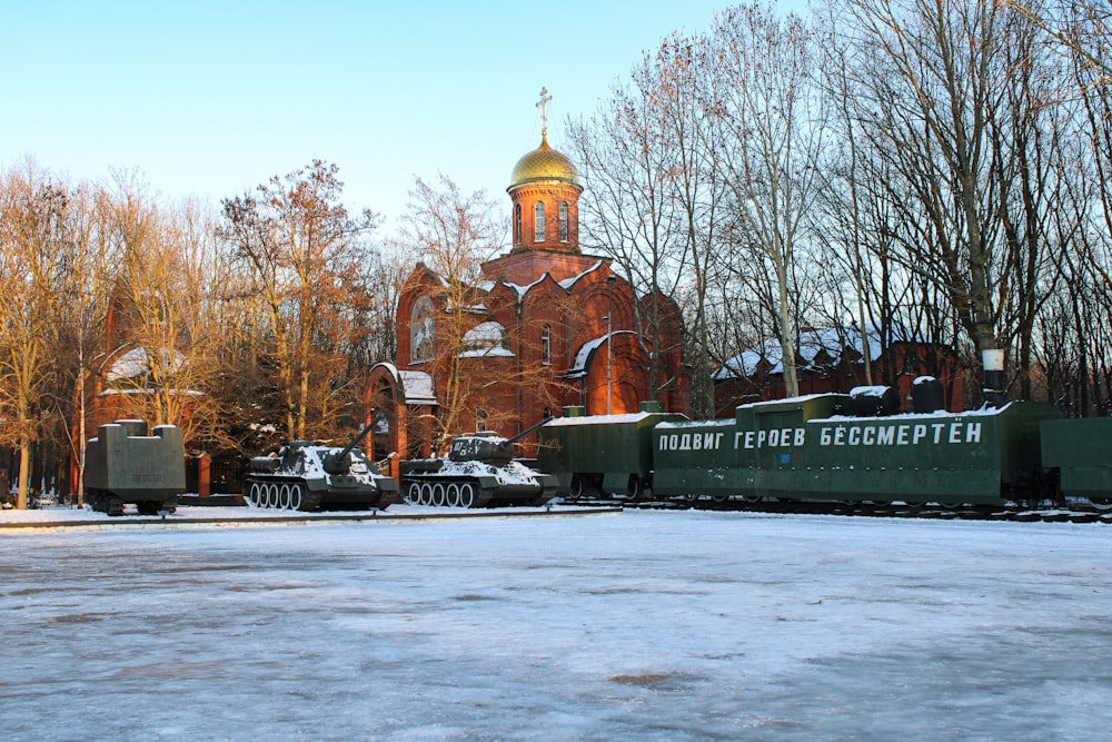 a train traveling past a church surrounded by trees